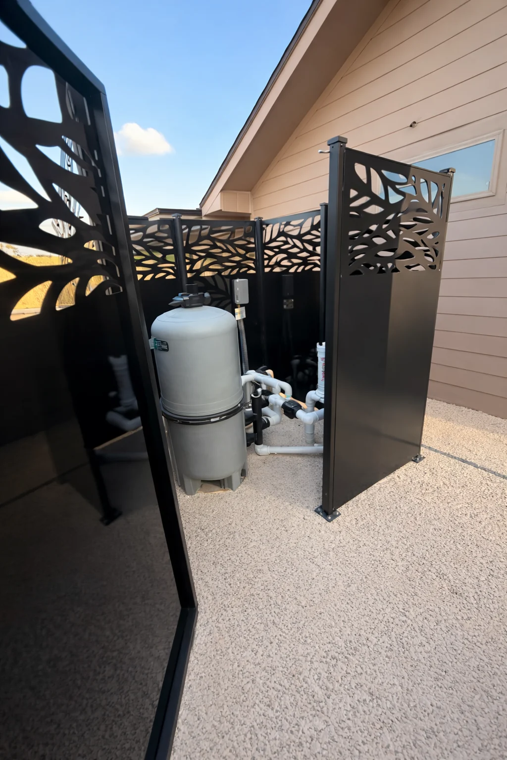 Black decorative panels surrounding outdoor mechanical equipment beside a home