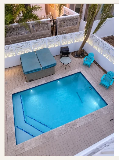White decorative privacy fence surrounding a backyard pool